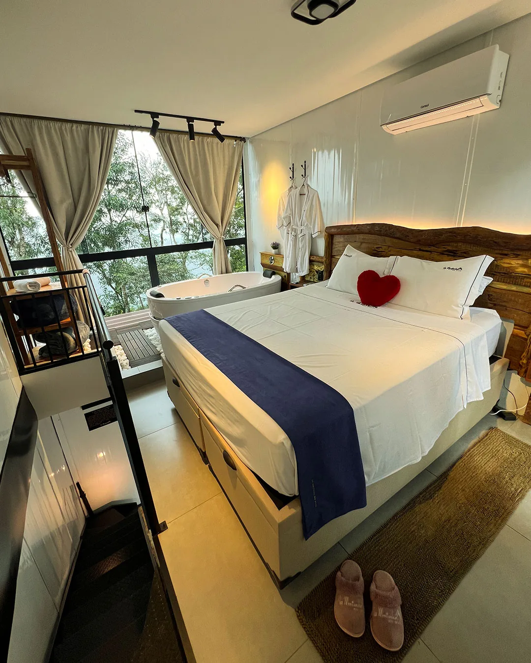 Quarto com cama de casal e janela grande