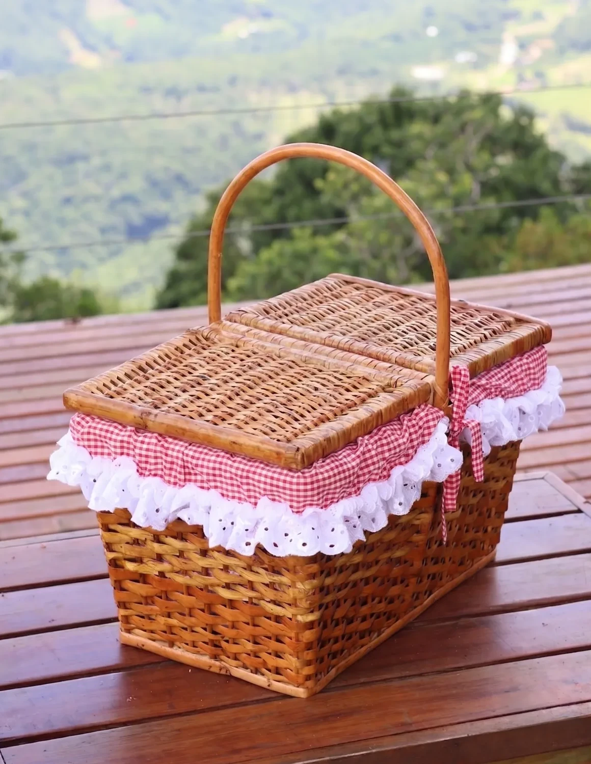 Cesta de vime do café da manhã sobre a mesa do deck