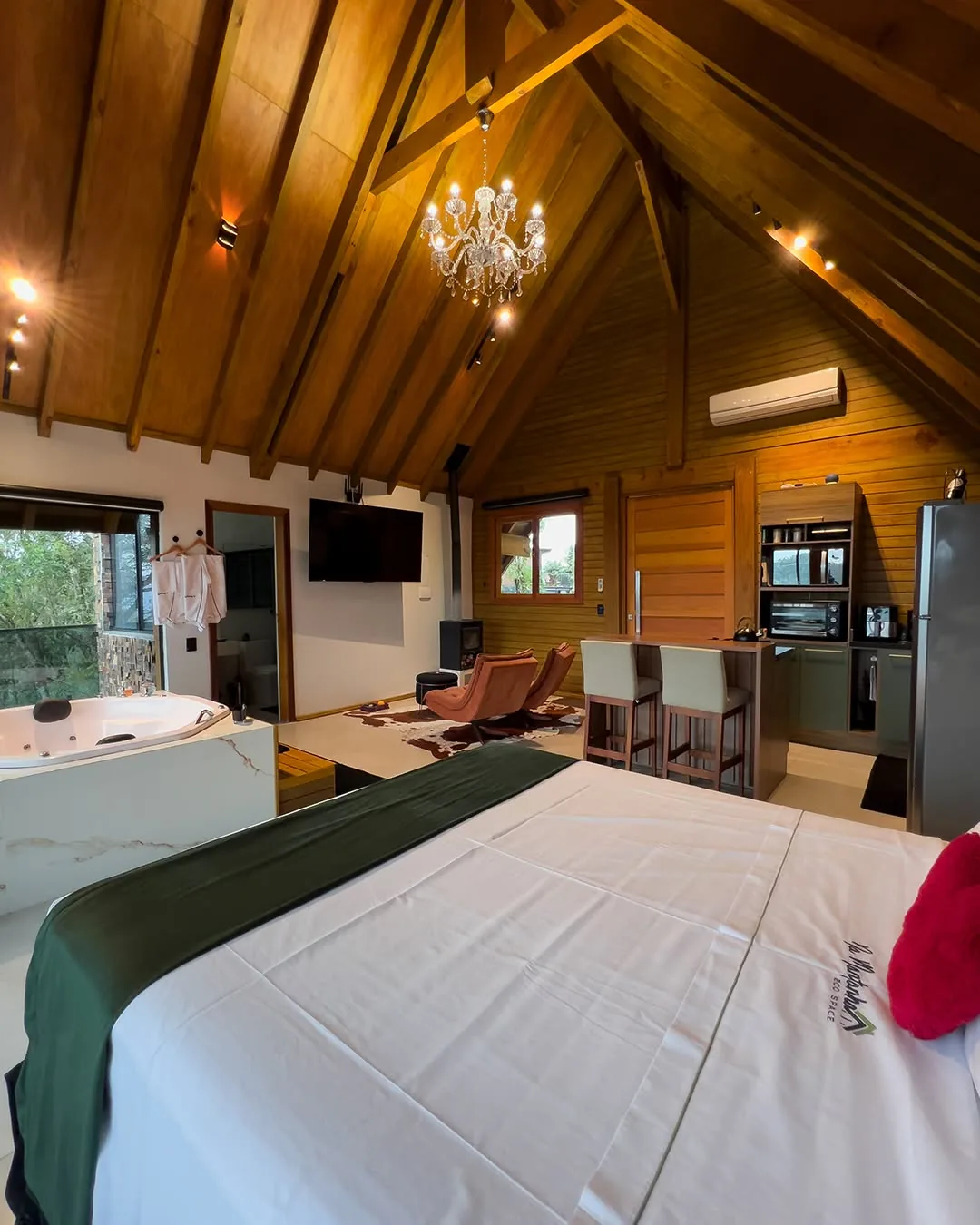 Cama de casal com a banheira de hidromassagem ao fundo