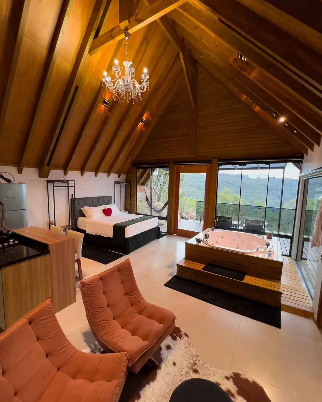 Interior com teto de madeira, cama e banheira