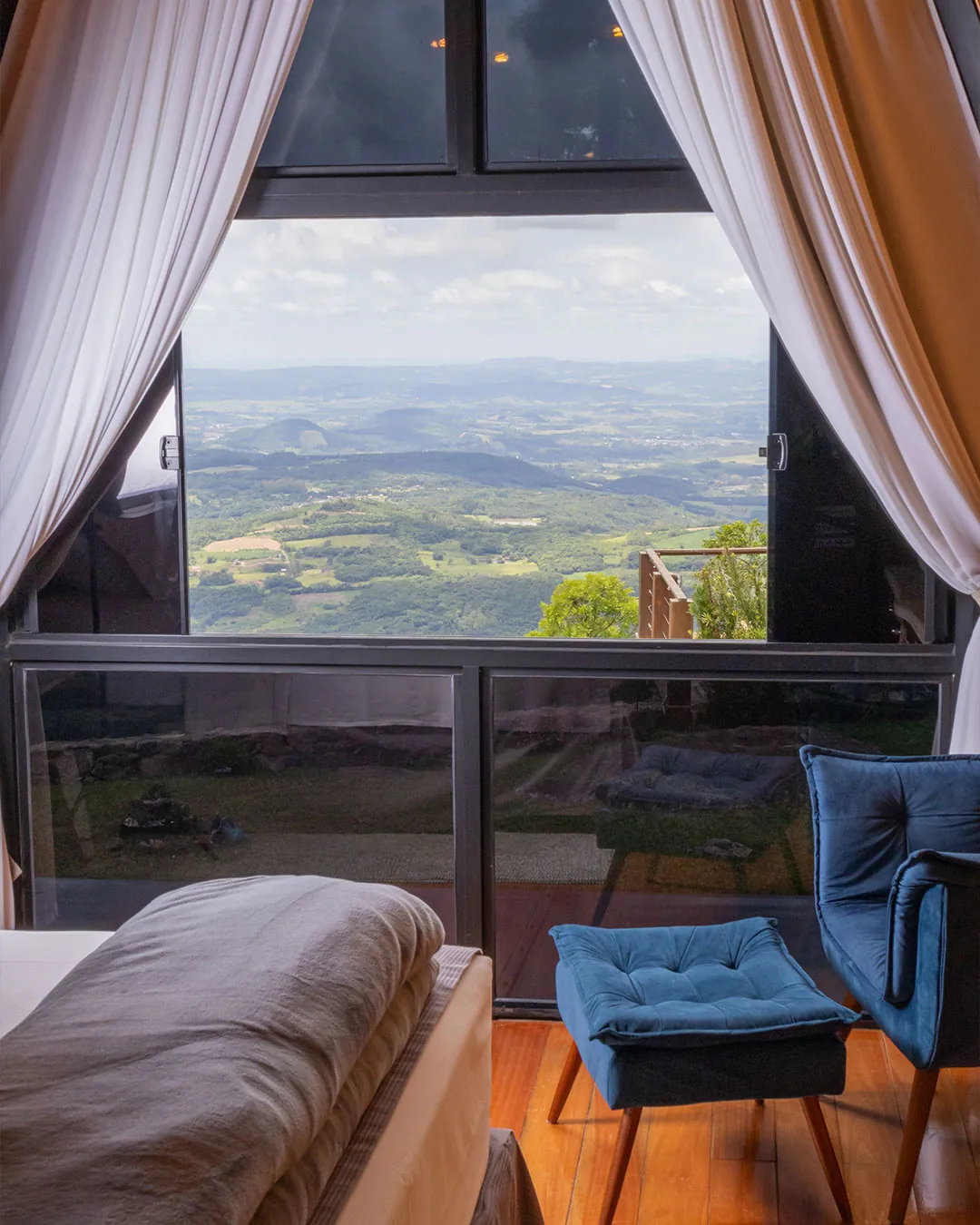 Janela triangular da Cabana dos Sonhos aberta para o vale