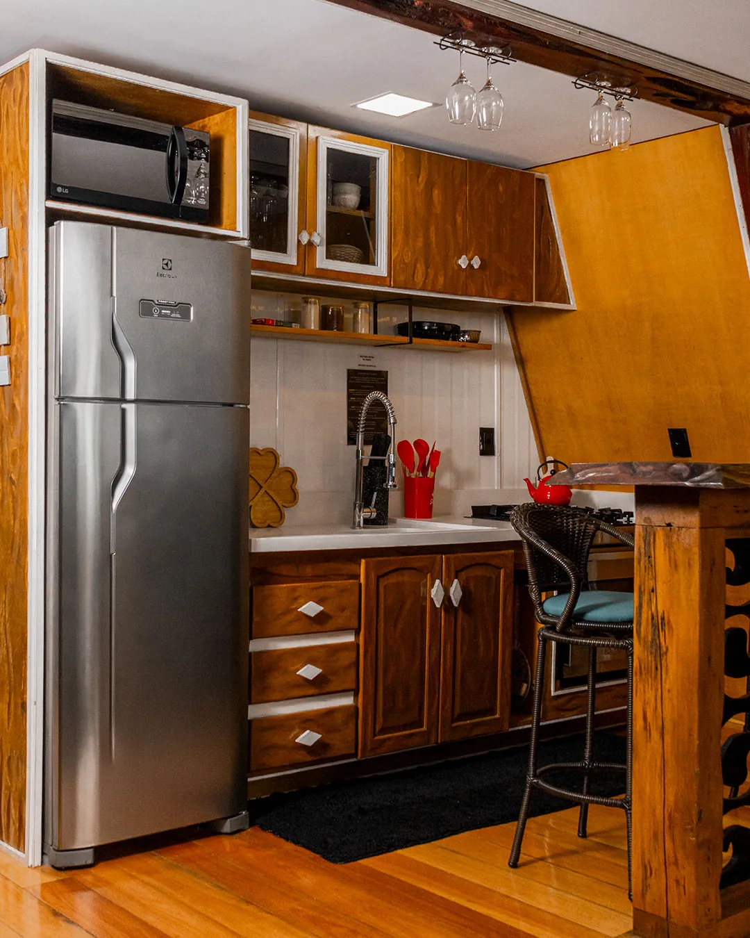 Cozinha com geladeira, armários e bancada