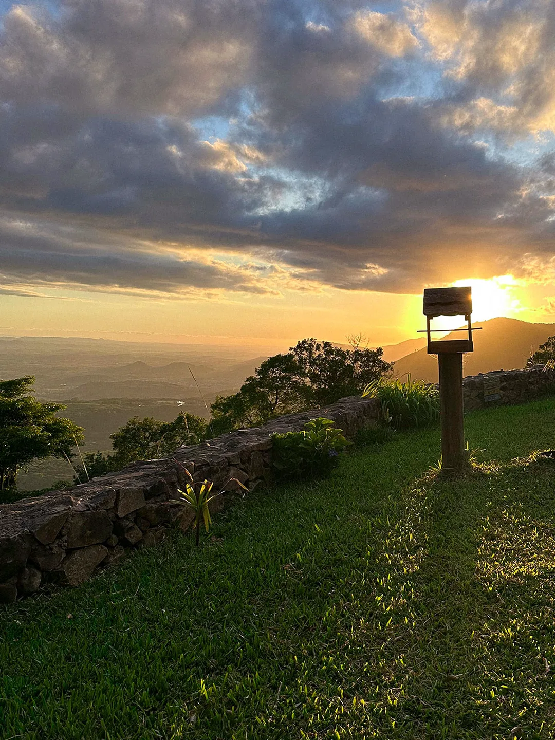 Pôr do sol sobre o gramado do terreno, com o vale ao fundo