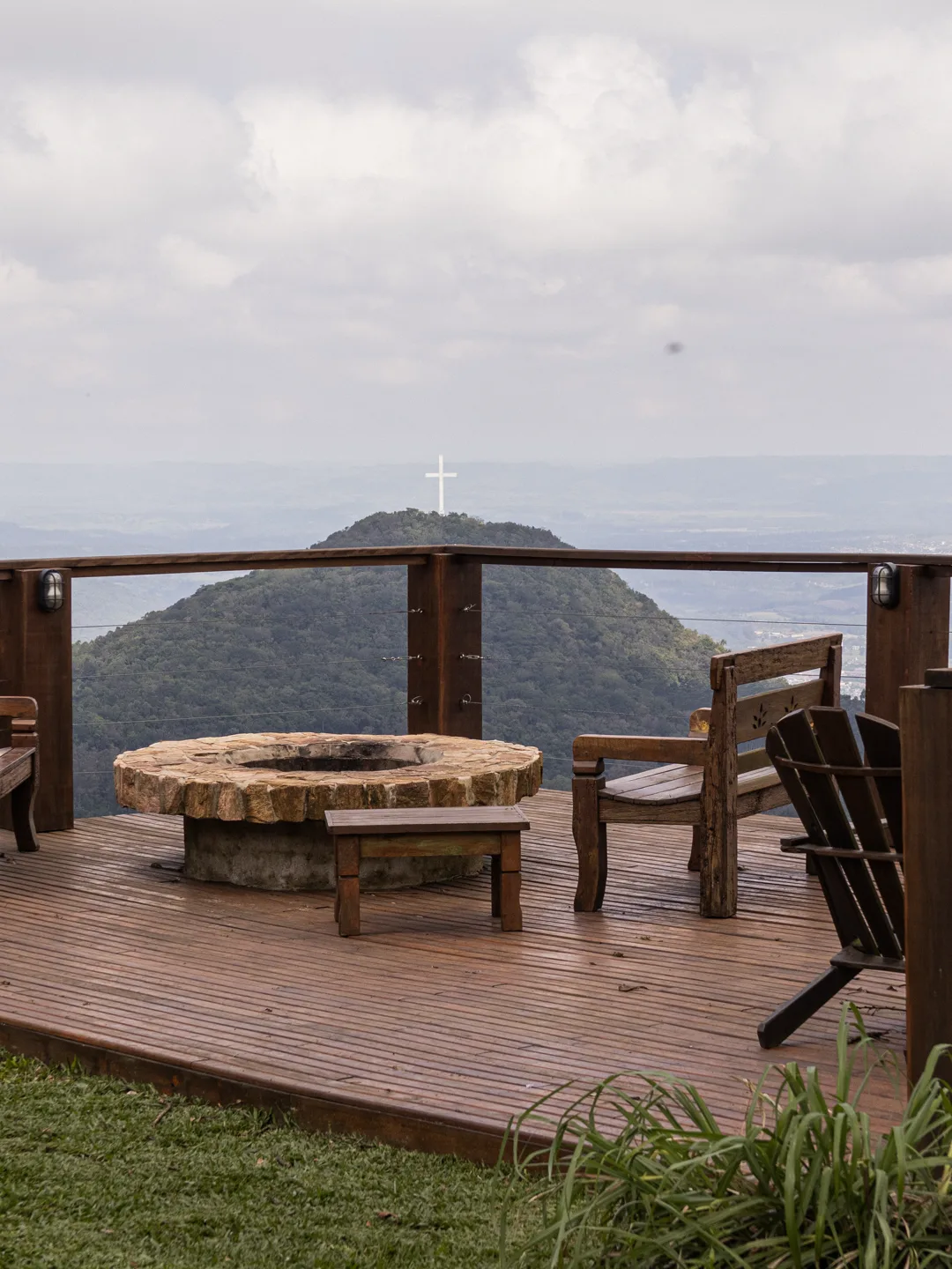 Fire pit no deck, com cadeiras e a serra ao fundo